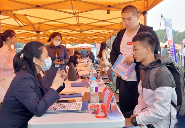 f90372e47e674a858bd66eec71df5c62.jpg 应聘学生与用人单位人员交谈.jpg