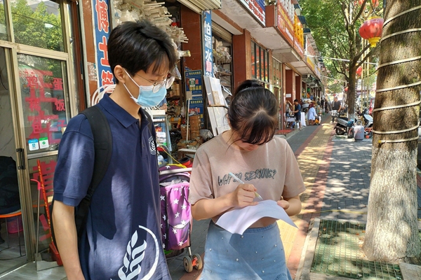 24ad16552b184c7a83679823dbec51fe.jpg 队员对群众进行问卷调查.jpg